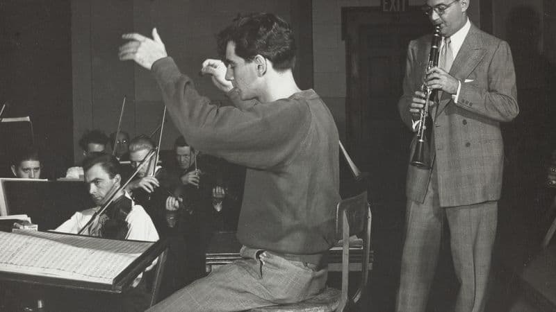 Leonard Bernstein conducting as Benny Goodman rehearses with an orchestra