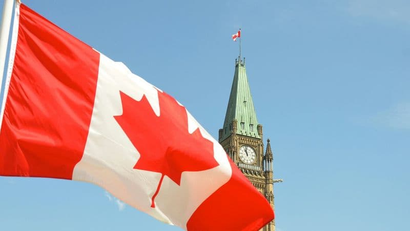 Canadian flag waving in front of the Peace Tower on Parliament Hill in Ottawa