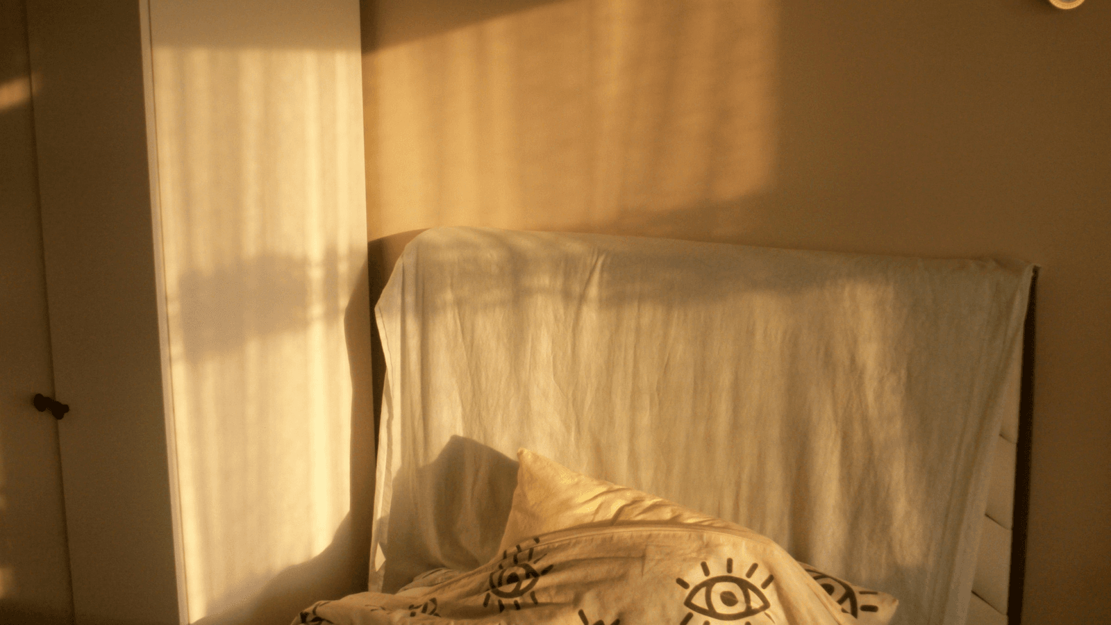 A quiet bedroom glowing with warm late-afternoon sunlight