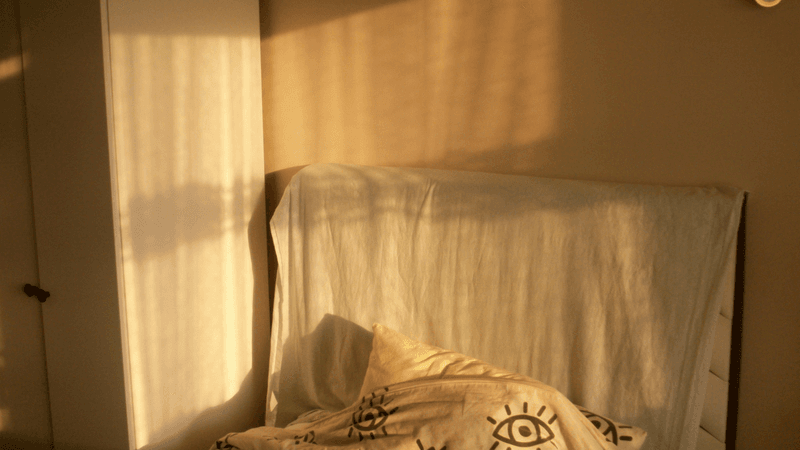 A quiet bedroom glowing with warm late-afternoon sunlight