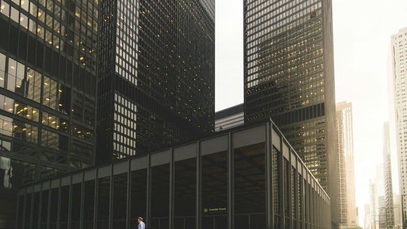 A pedestrian crossing Toronto's financial district beside bank towers