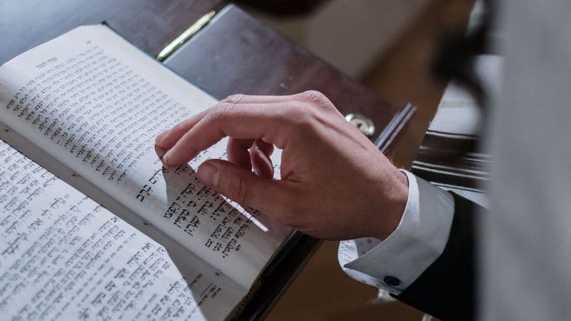 Close-up of a Jewish worshipper following Hebrew text in a siddur